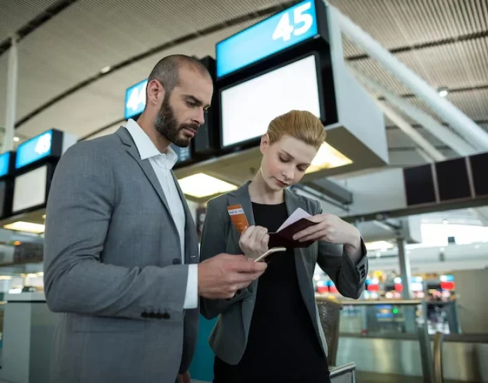 Business people holding boarding pass and using mo
